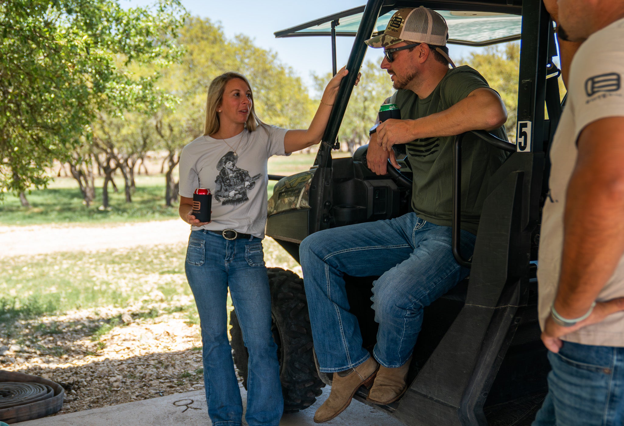 Two people interacting with a four-wheeler in an outdoor setting