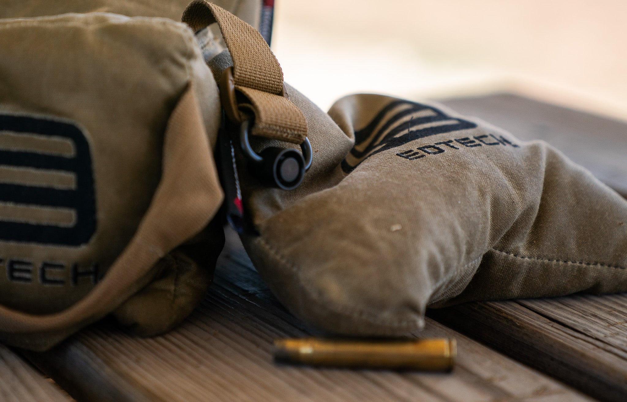 Close-up of shooting bags with EOTECH branding on a wooden surface.