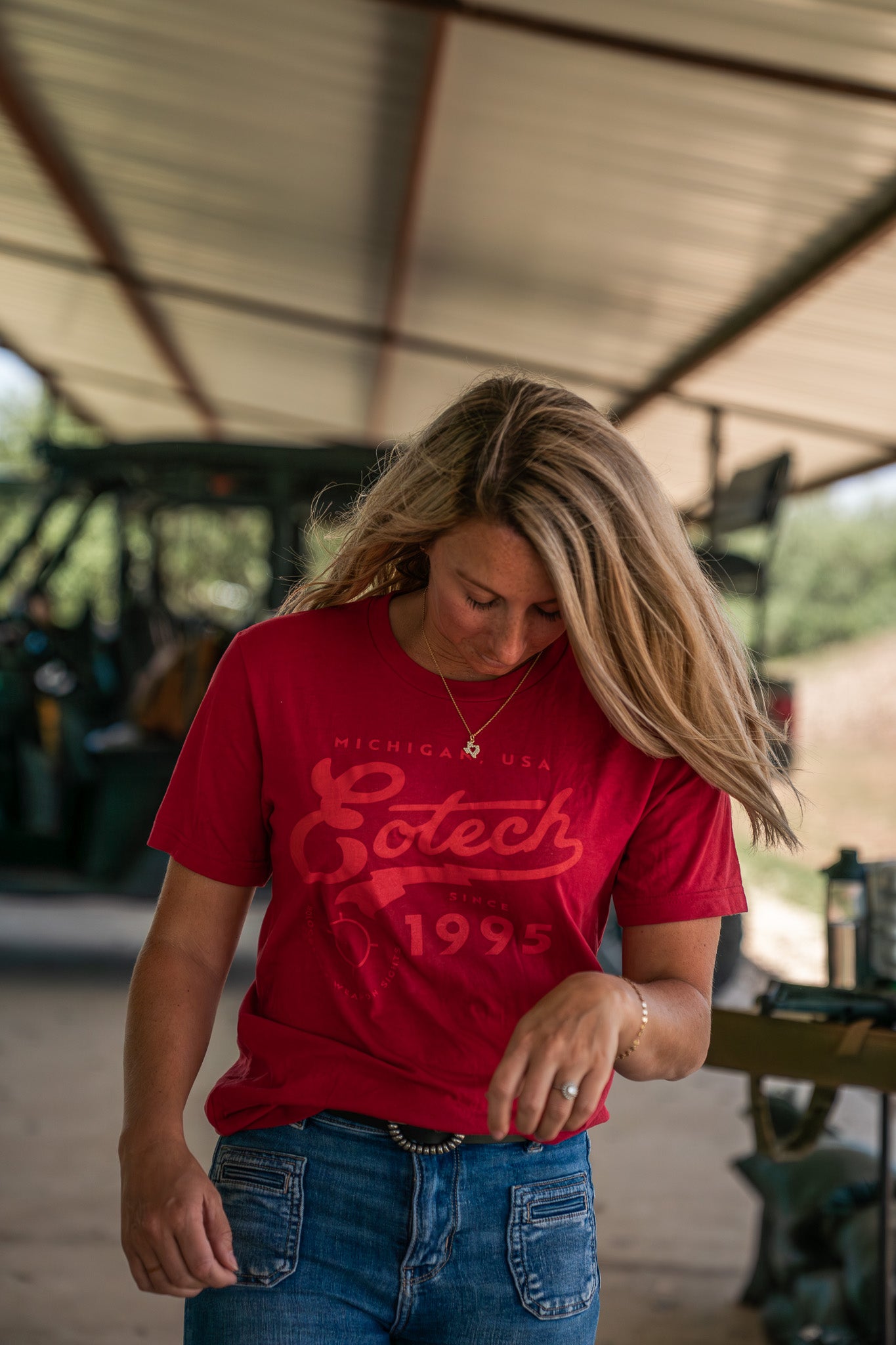 Woman wearing a red EOTECH shirt in an outdoor setting