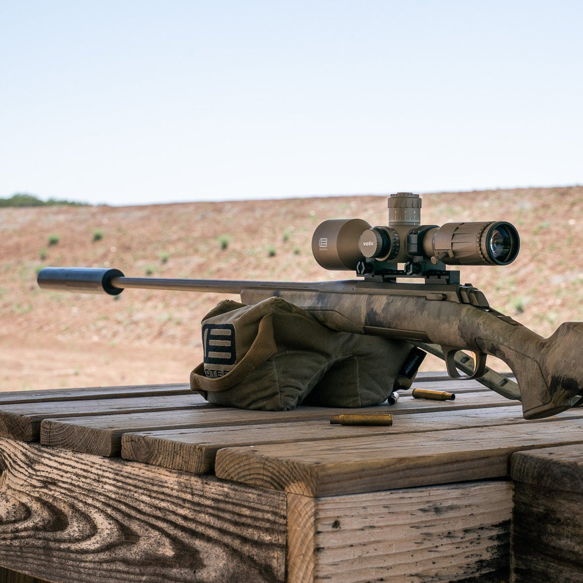EOTECH Vudu Tan Riflescope on a wooden bench with a scenic