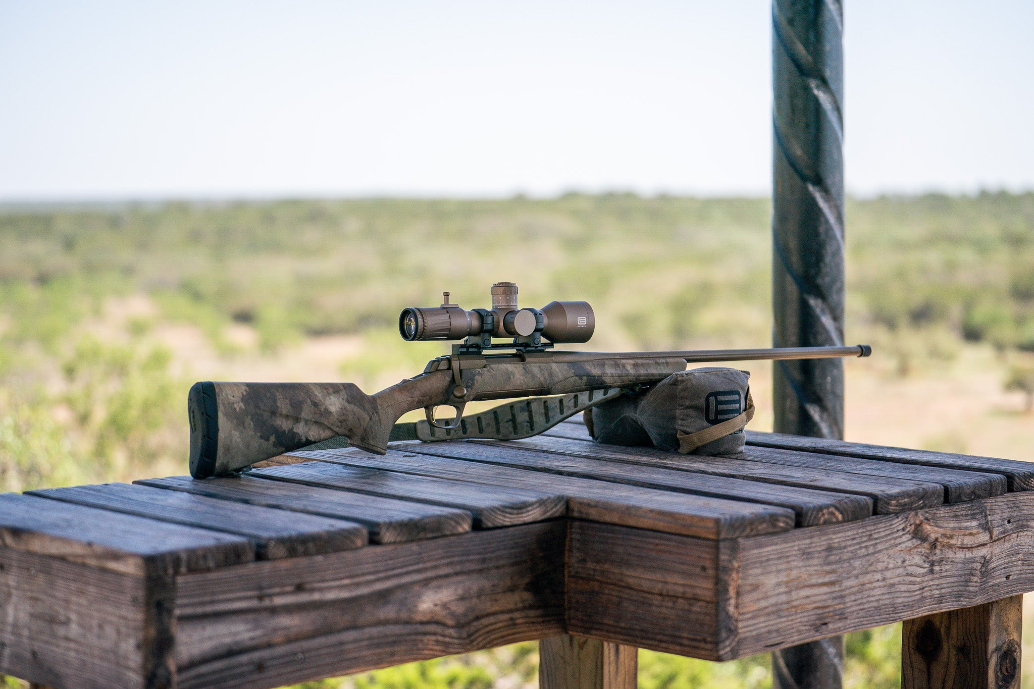 EOTECH Vudu Tan Riflescope on a wooden bench with a scenic background