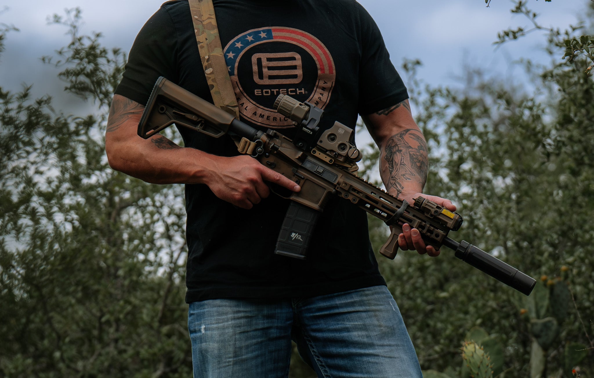 Person holding a rifle EOTECH HWS optic and EOTECH logo in natural background