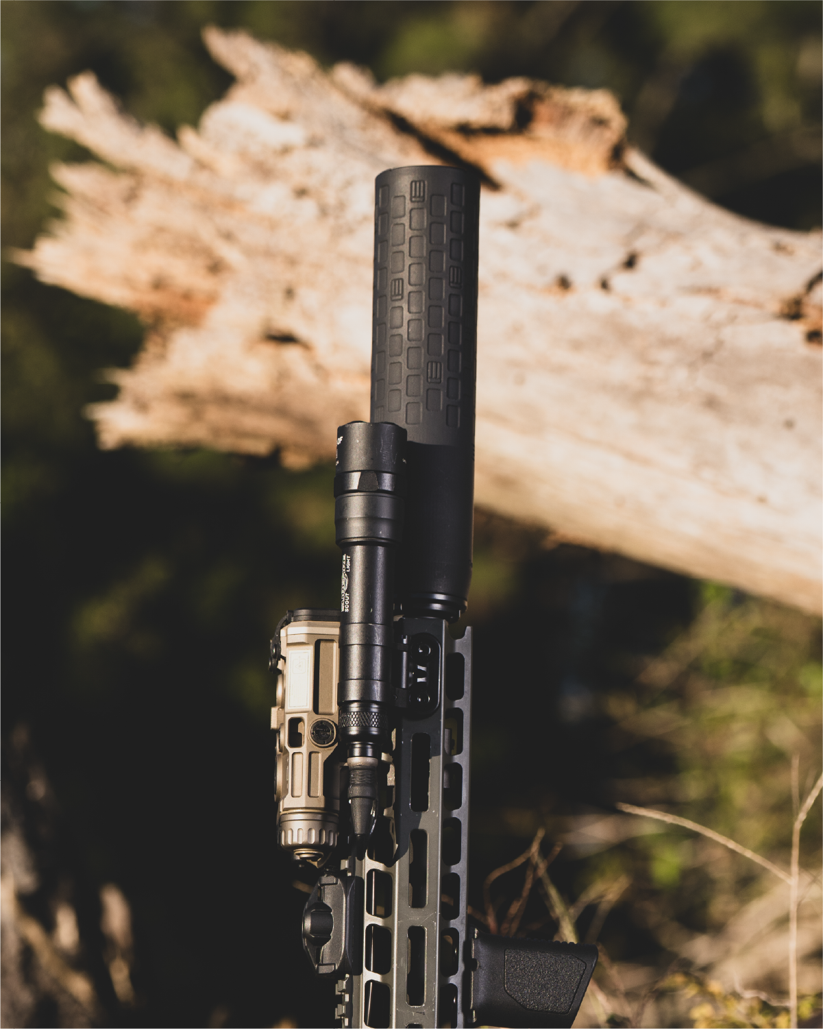 Black rifle with EOTECH DCBL suppressor and OGL against a natural background