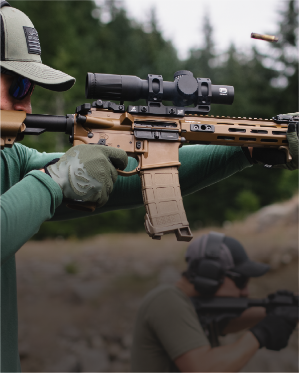 Person aiming a rifle with a EOTECH Vudu black scope in a forest setting