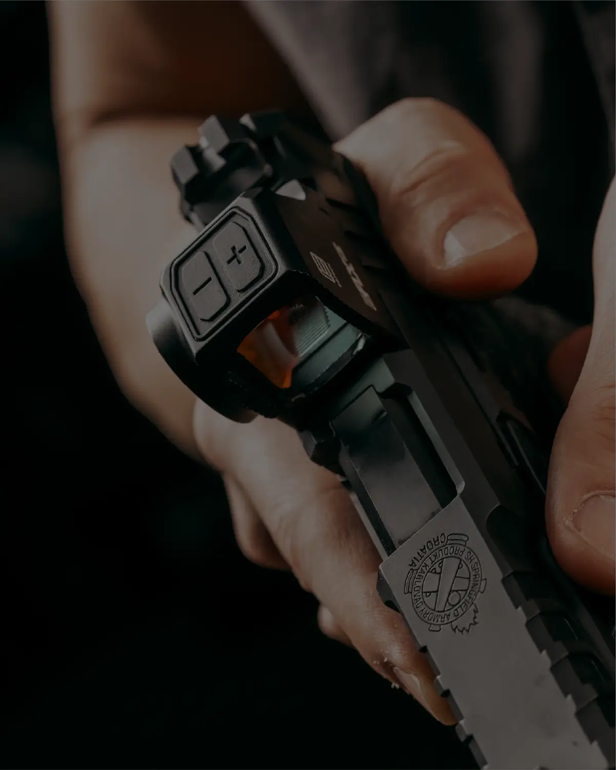 Close-up of a person holding a pistol with a focus on the EFLX CE.