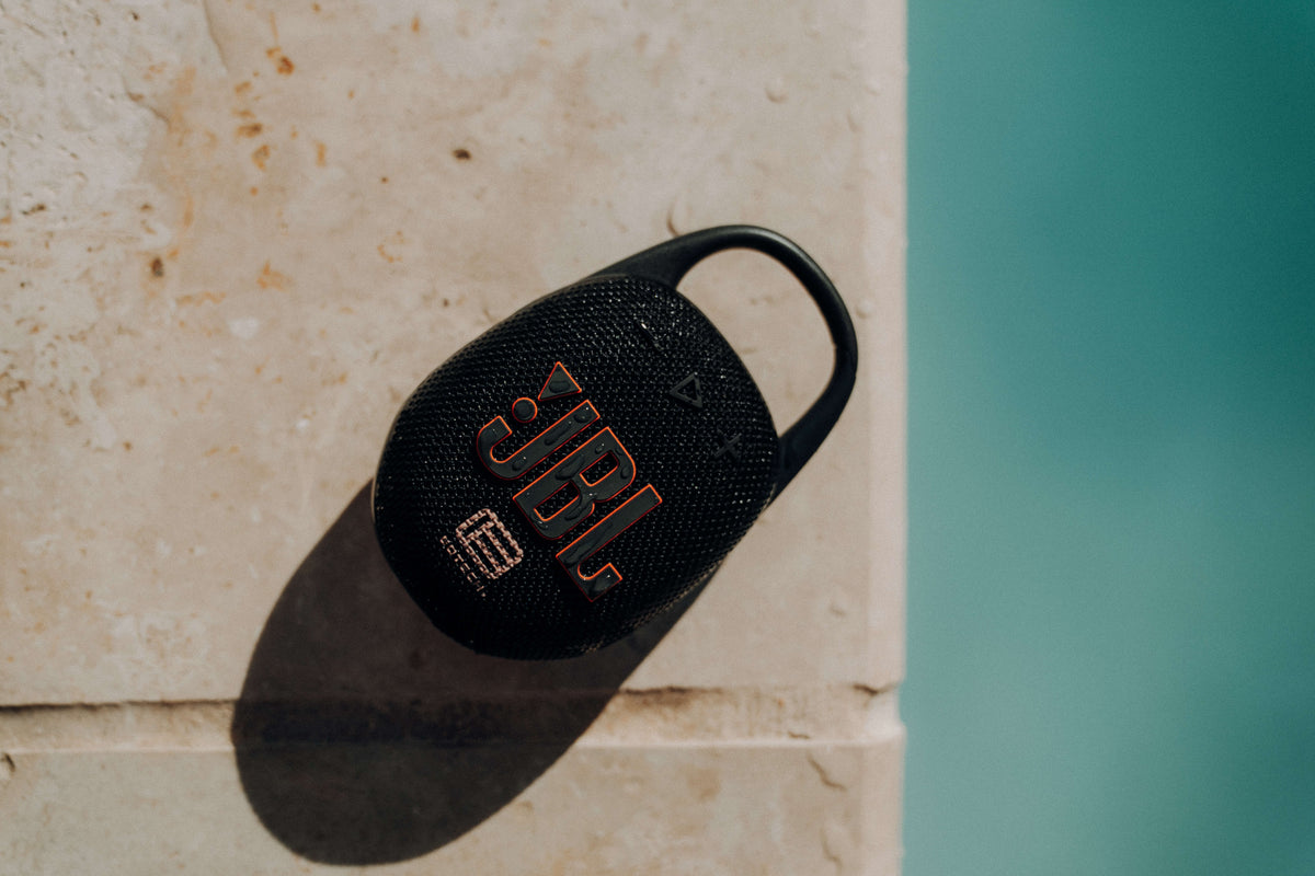 JBL Speaker laying down on concrete with pool in view, EOTECH logo visible on speaker