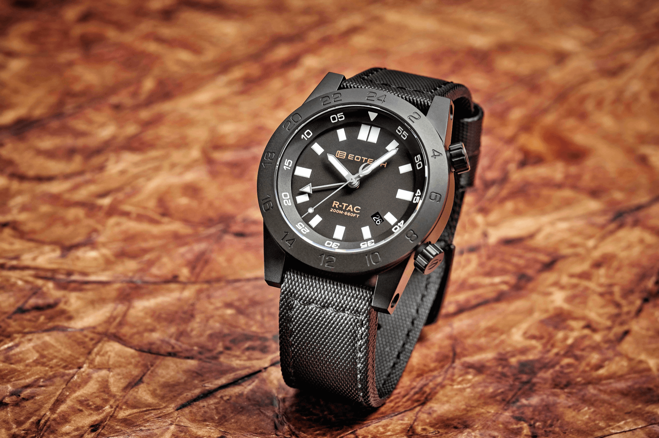 Black watch with detailed design on a textured brown background