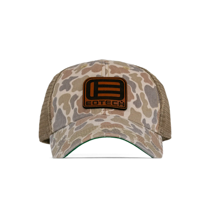 A duck camouflage trucker hat with tan mesh back panels and a brown leather patch on the front featuring the EOTECH logo.