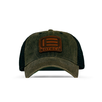 A dark olive green and black trucker-style baseball cap with a brown leather patch on the front featuring the EOTECH logo, shown against a plain white background.