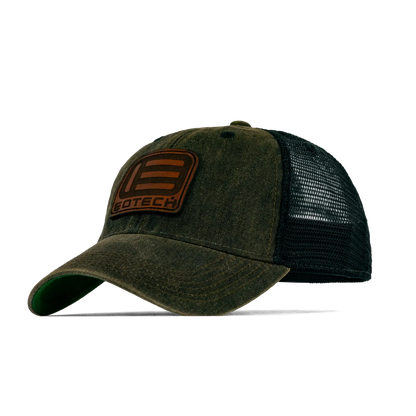 A trucker-style baseball cap with a washed olive green front panel and brim, black mesh back, and a brown leather patch on the front displaying the brand name 'EDTECH'.