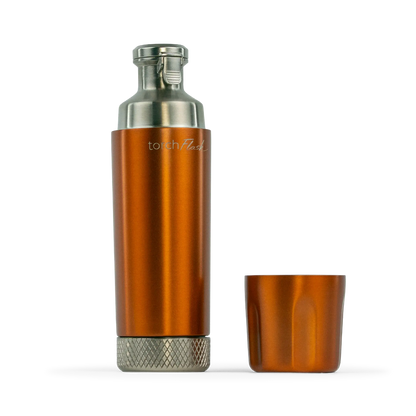 An copper metallic cylindrical flask with a silver top and bottom, shown next to its matching copper top on a white background. The brand name 'torch flask' is visible on the side of the flask