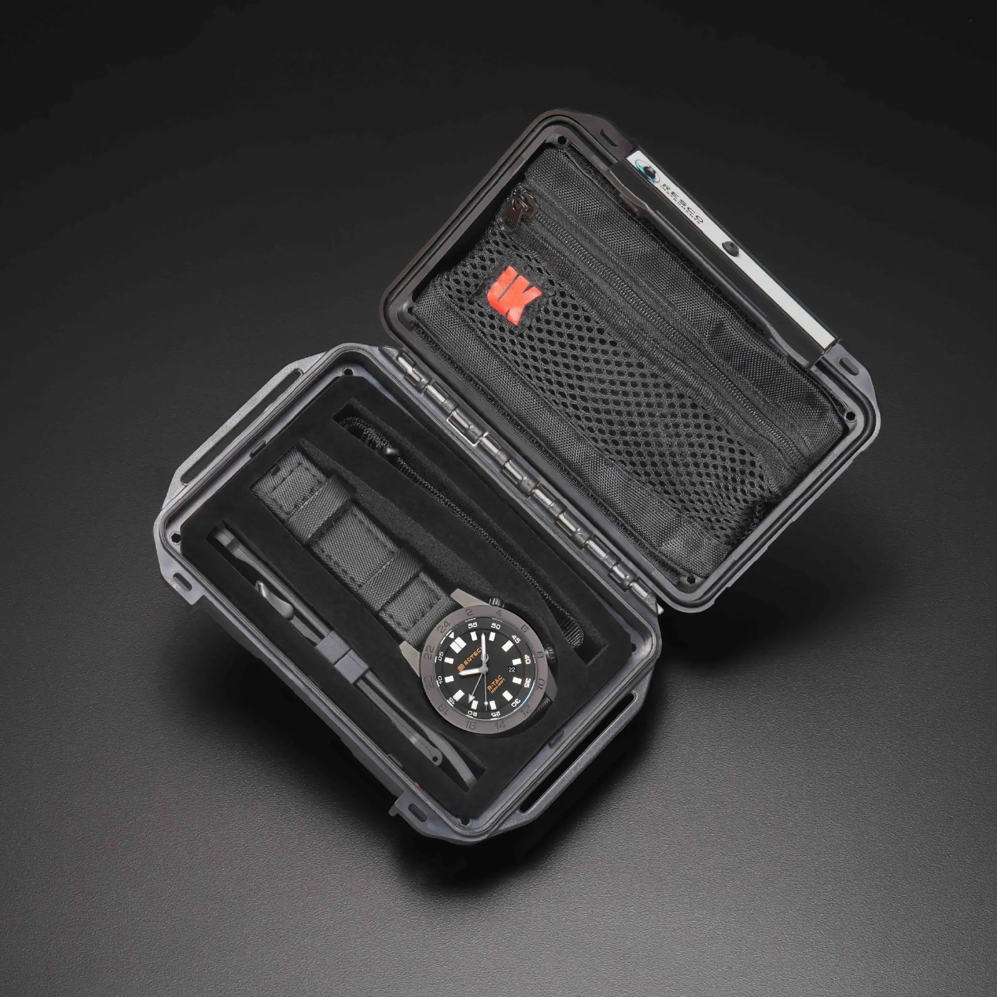 Black watch case with a watch inside on a dark background