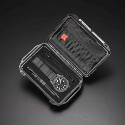 Black watch case with a watch inside on a dark background