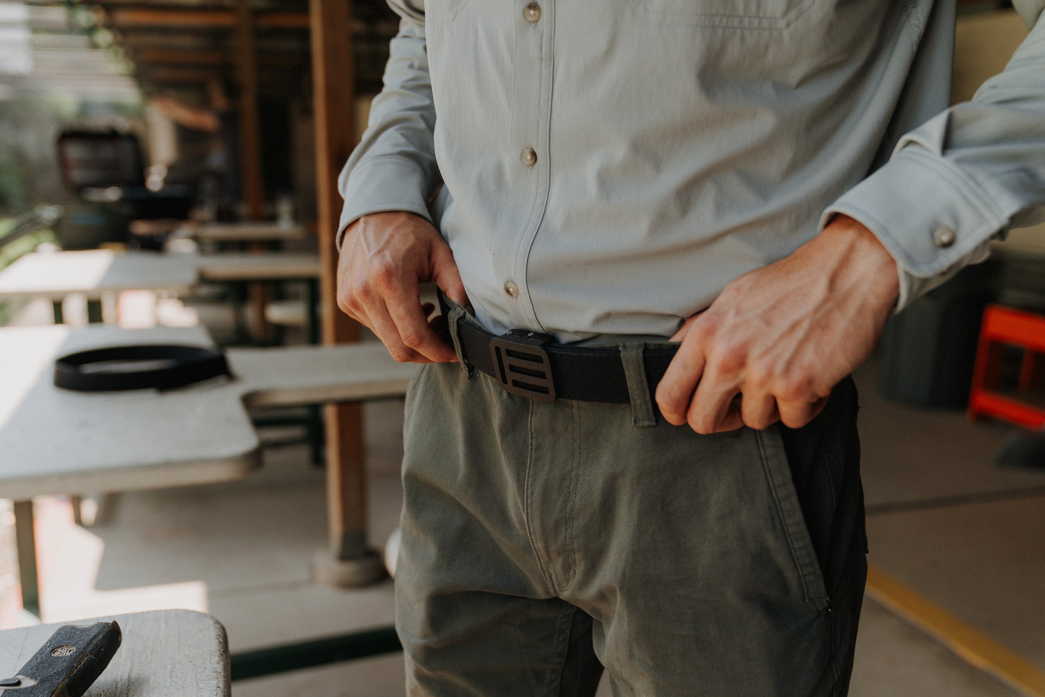 Person adjusting the black EOTECH EDC belt in an indoor range