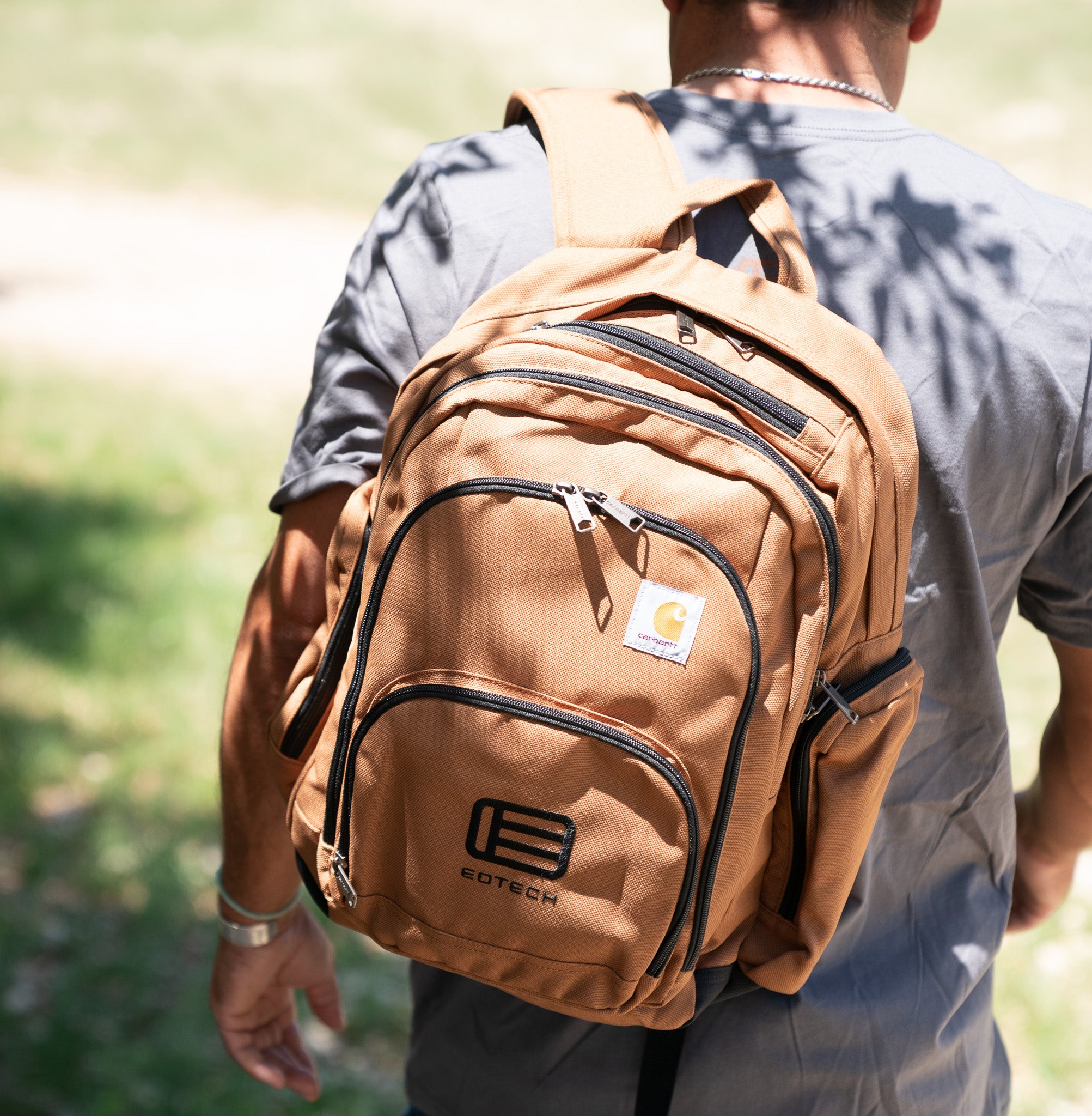 Person wearing a tan EOTECH backpack outdoors