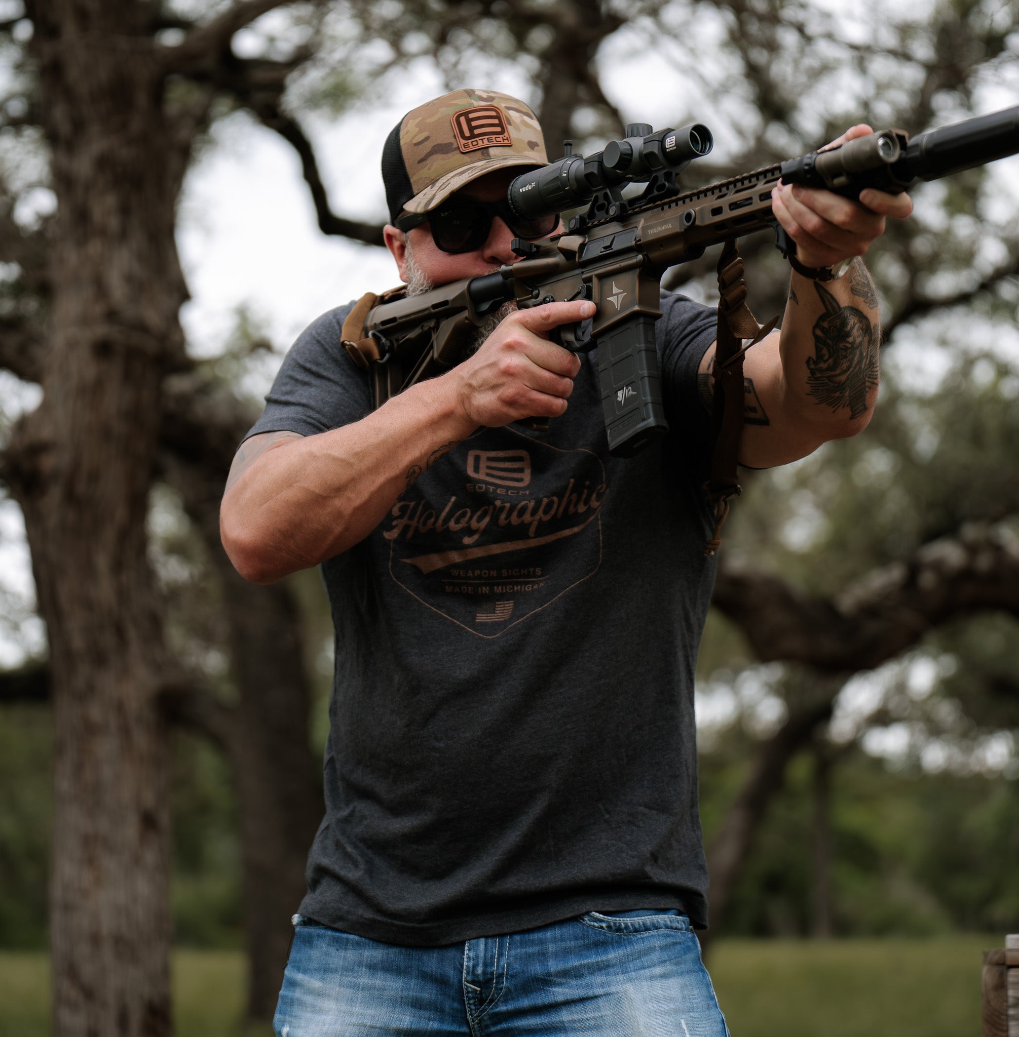 Man holding a rifle with a EOTECH Vudu scope in a natural setting