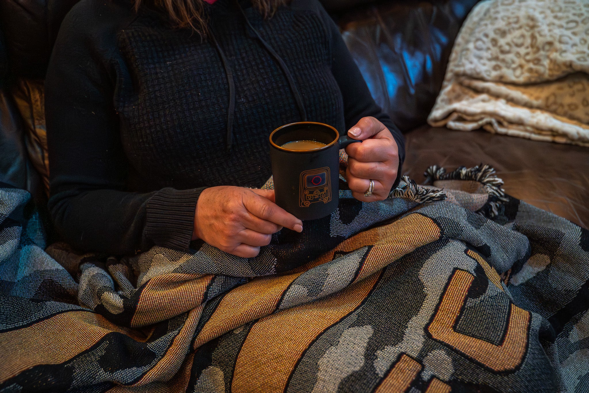 Woman wearing a blanket and  holding EOTECH mug 