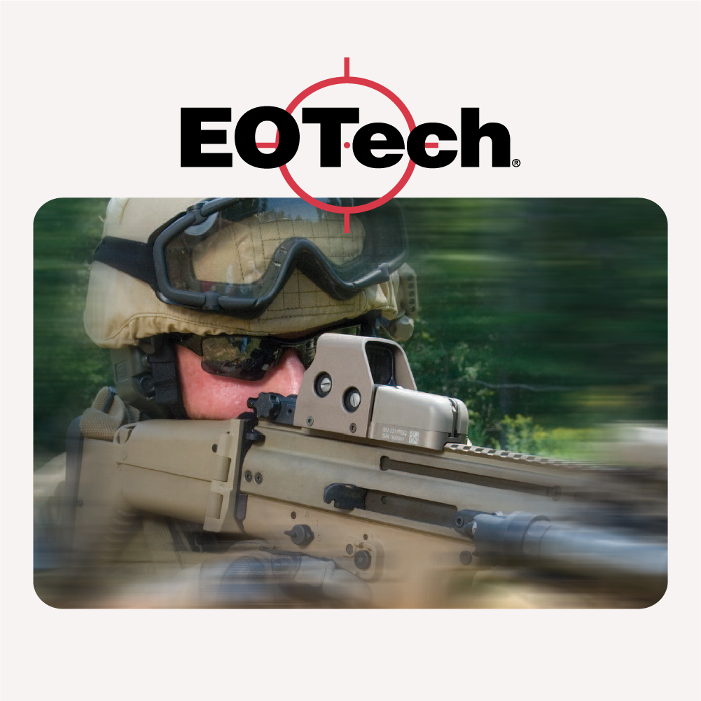 Military person using EOTECH equipment with a rifle, blurred green background