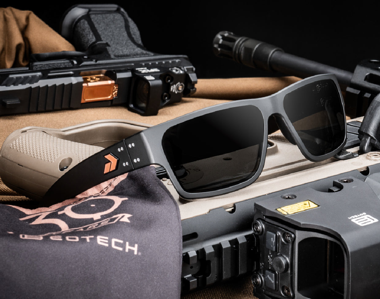 Sunglasses on a table with tactical gear in the background and EOTECH pouch