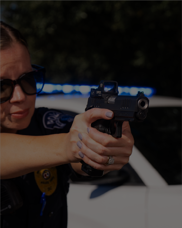 Law Enforcement Woman holding a handgun with a EOTECH EFLX red dot in the background