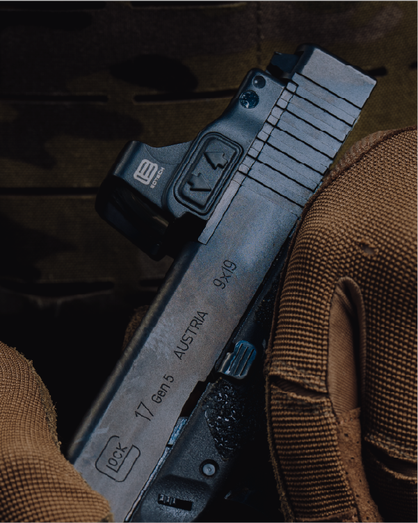 Close-up of a firearm with a EOTECH EFLX on a wooden surface