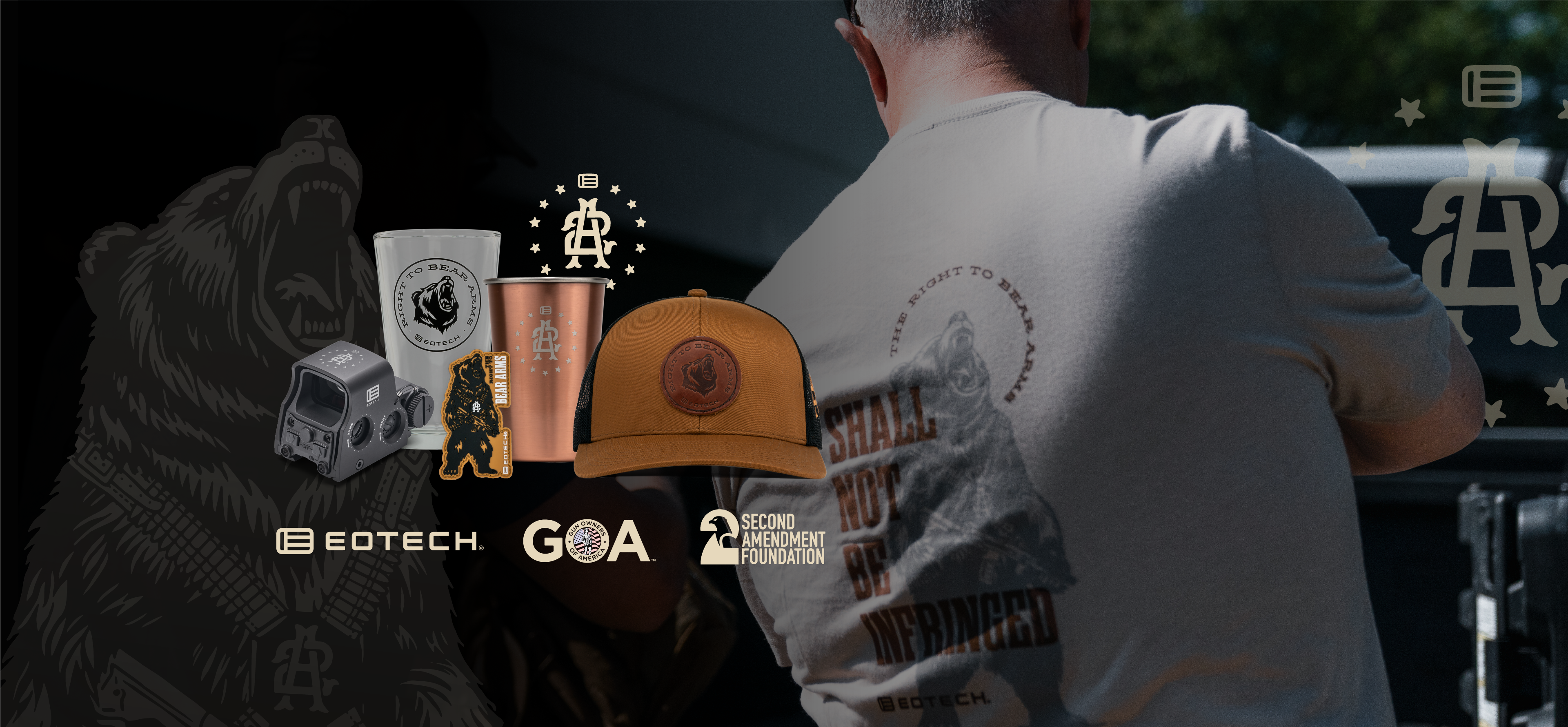 Man wearing a EOTECH  t-shirt with a bear graphic, surrounded by branded merchandise and logos.