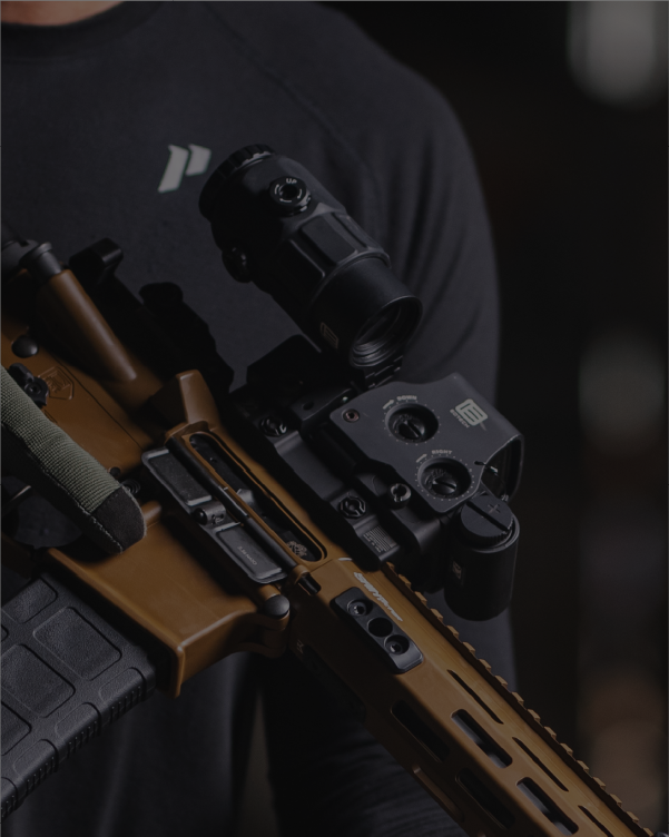 Close-up of a copper rifle with EOTECH HWS optic and magnifier on a dark background