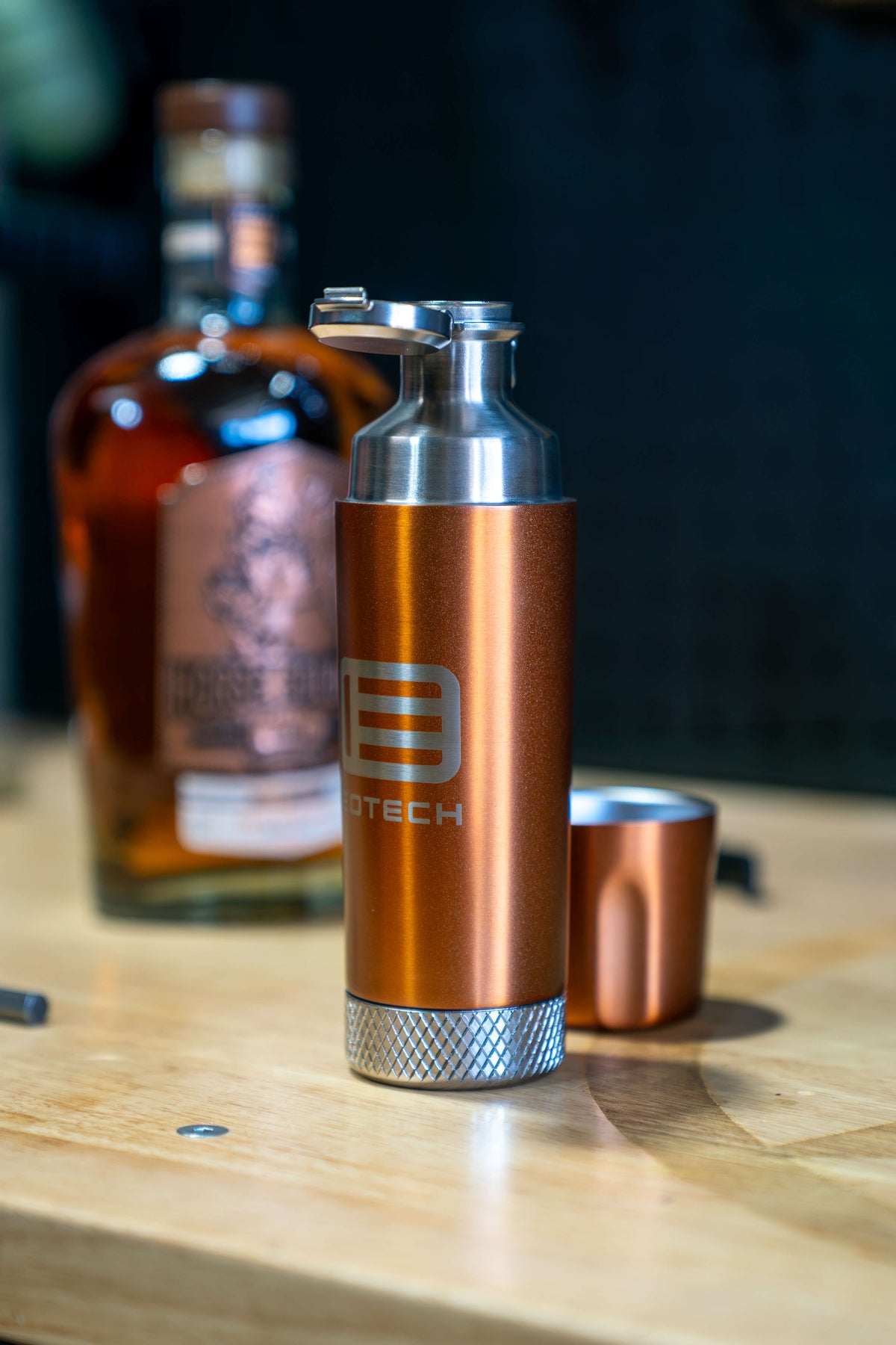 EOTECH Torch Flask with the_lid open and the top cup off to the side bourbon in the background