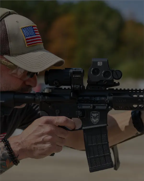 Man holding a rifle with a HHS Unity on a range
