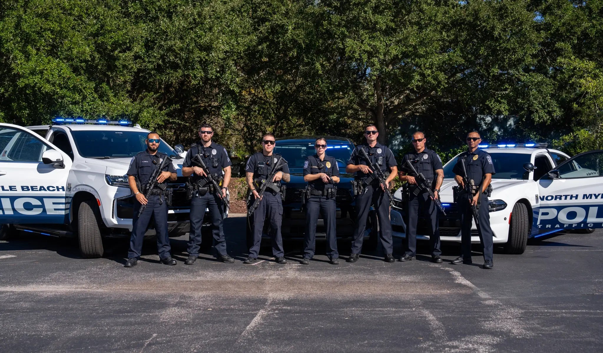 Law Enforcement Officers standing in front of squad vehicles