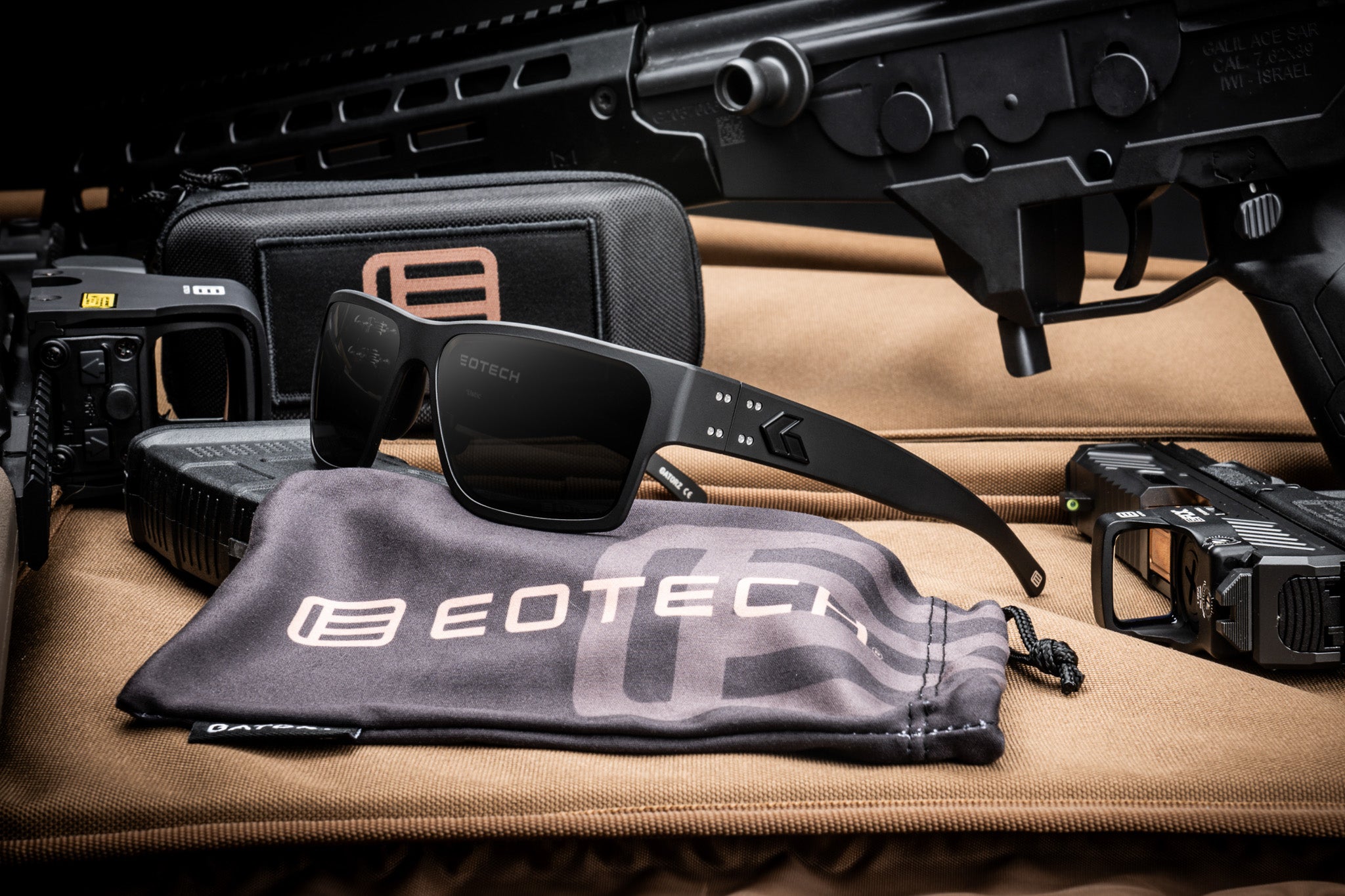 EOTECH Sunglasses on a branded cloth with tactical gear in the background